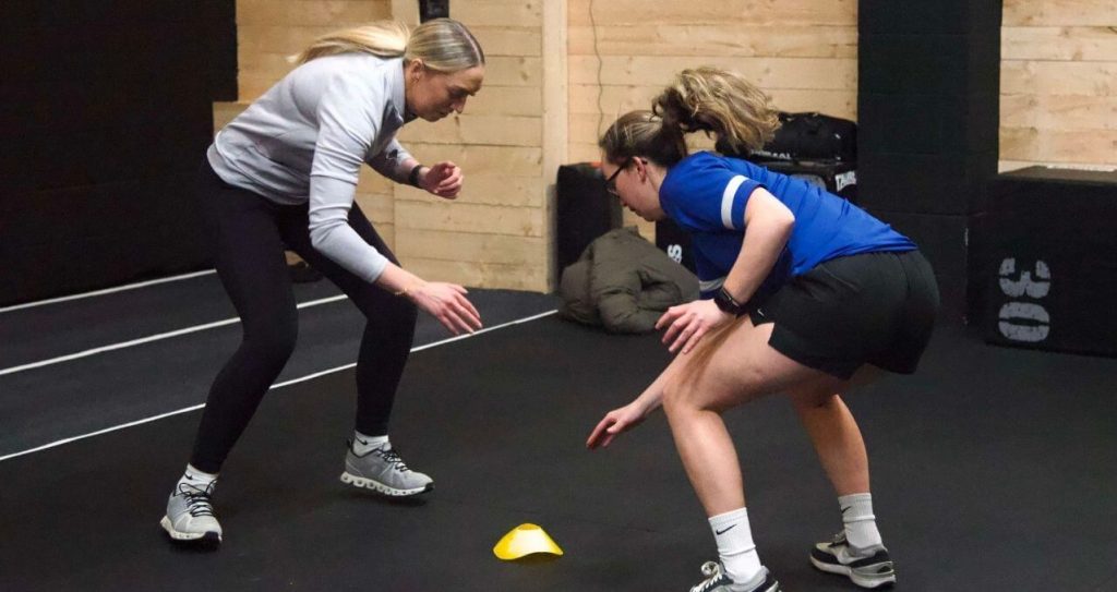 Personal trainer coaching during group strength class